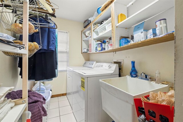 laundry room featuring separate washer and dryer, sink, and light tile patterned floors