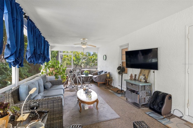 living room featuring ceiling fan, carpet floors, and a textured ceiling