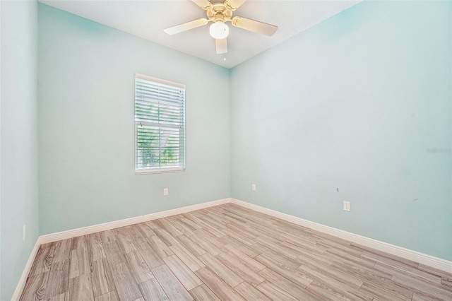 spare room with light wood-type flooring, baseboards, and a ceiling fan