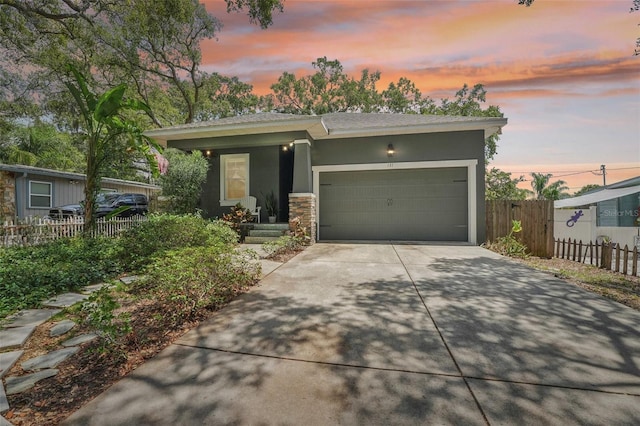 view of front facade with a garage, covered porch, fence, concrete driveway, and stucco siding