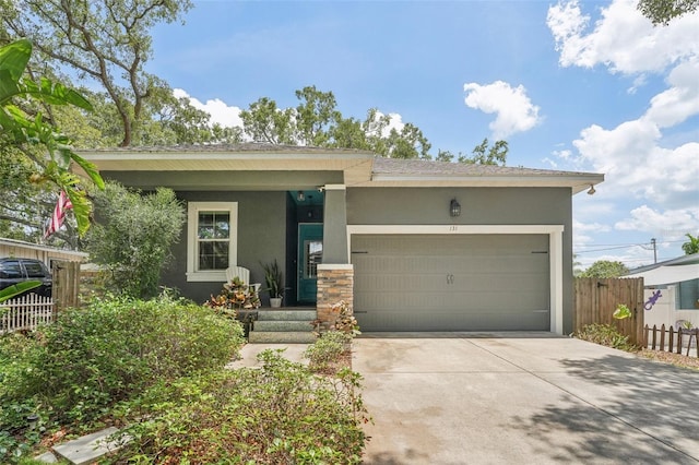 view of front of home featuring an attached garage, fence, concrete driveway, and stucco siding