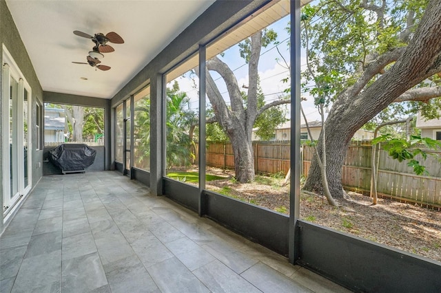 unfurnished sunroom featuring a ceiling fan