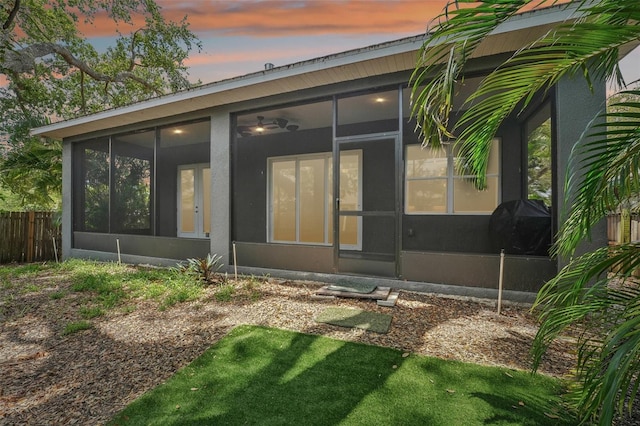 rear view of property with fence and a sunroom