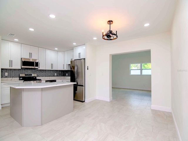 kitchen with white cabinetry, hanging light fixtures, and appliances with stainless steel finishes