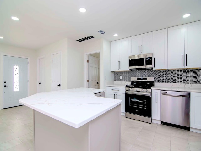 kitchen featuring stainless steel appliances, a kitchen island, and white cabinets