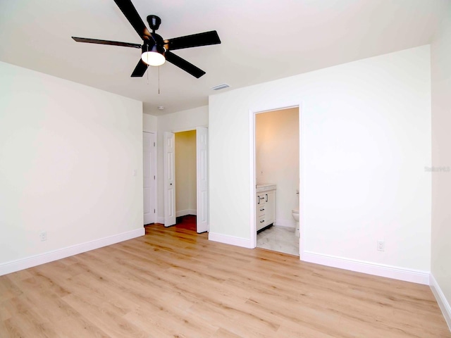 unfurnished bedroom featuring ensuite bath, ceiling fan, and light wood-type flooring