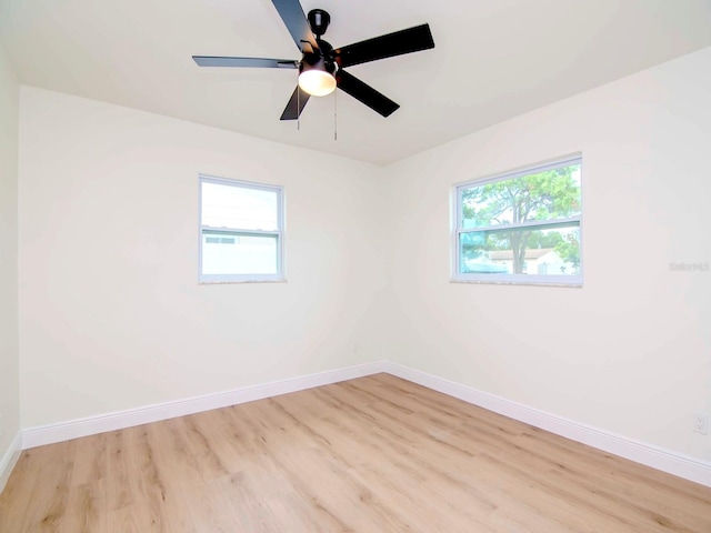 spare room with a healthy amount of sunlight, ceiling fan, and light hardwood / wood-style flooring