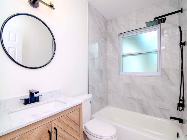 full bathroom featuring vanity, tiled shower / bath, and toilet