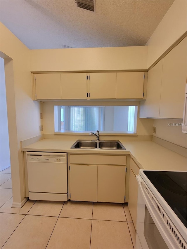 kitchen with a textured ceiling, sink, dishwasher, range, and light tile patterned flooring