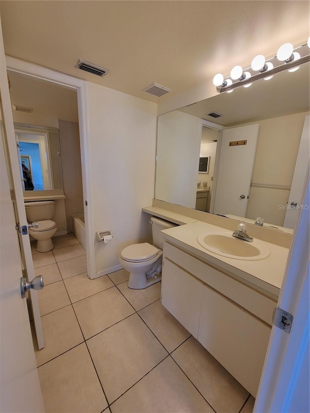 bathroom with a washtub, tile patterned floors, vanity, and toilet