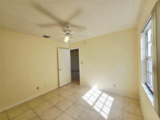 6802 Stones Throw Cir N Unit 14206, Saint Petersburg, FL 33710 - spare room featuring ceiling fan, light tile patterned floors, a textured ceiling, and baseboards