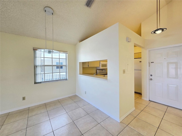 6802 Stones Throw Cir N Unit 14206, Saint Petersburg, FL 33710 - foyer featuring light tile patterned floors, lofted ceiling, a textured ceiling, and baseboards