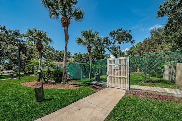 view of gate featuring a lawn and fence