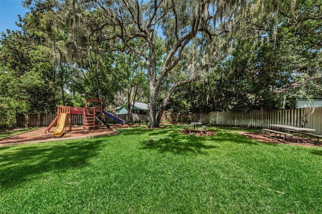 view of yard with a playground and a fenced backyard