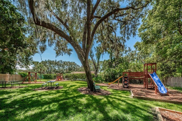 view of yard with playground community and fence