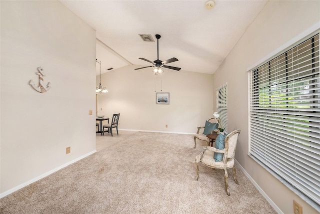 living area with carpet floors, lofted ceiling, visible vents, baseboards, and ceiling fan with notable chandelier