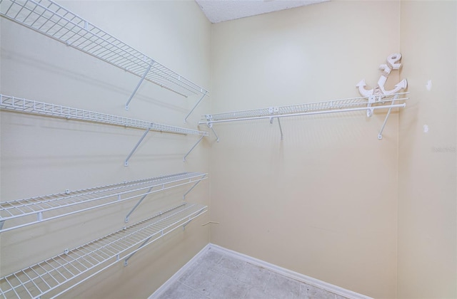 spacious closet with tile patterned floors