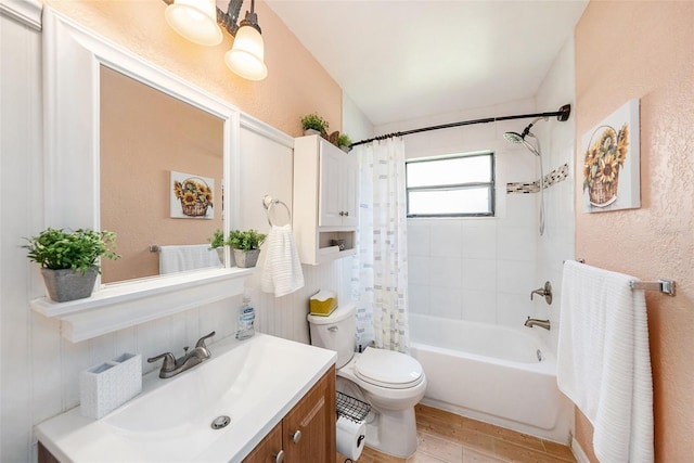 bathroom with a textured wall, toilet, wood finished floors, shower / bath combination with curtain, and vanity