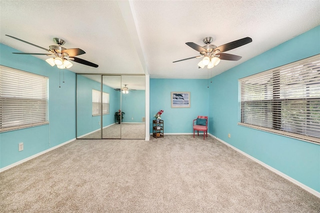 unfurnished bedroom featuring a closet, carpet flooring, a textured ceiling, and baseboards