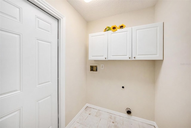 clothes washing area with washer hookup, cabinet space, electric dryer hookup, a textured ceiling, and baseboards