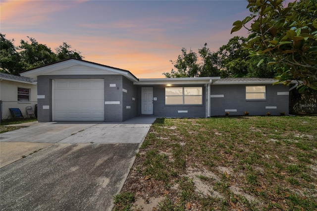 ranch-style home with a yard and a garage