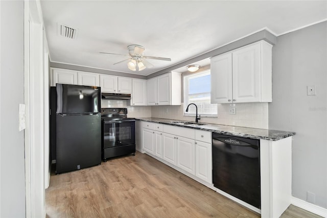 kitchen featuring black appliances, white cabinets, light wood-type flooring, and dark stone countertops