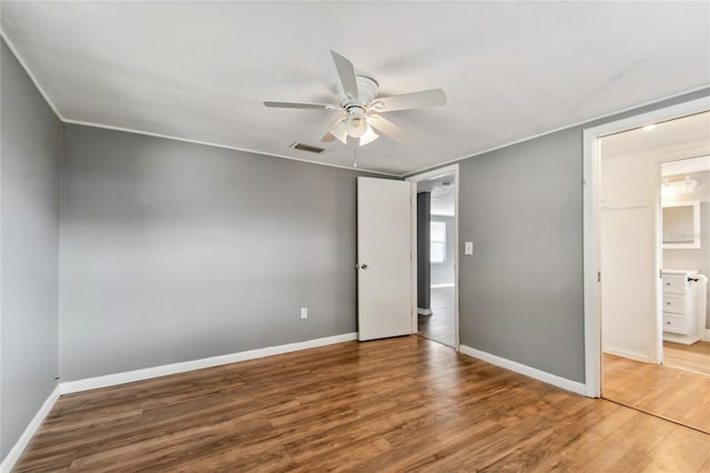 unfurnished bedroom featuring ceiling fan, wood-type flooring, and ensuite bathroom