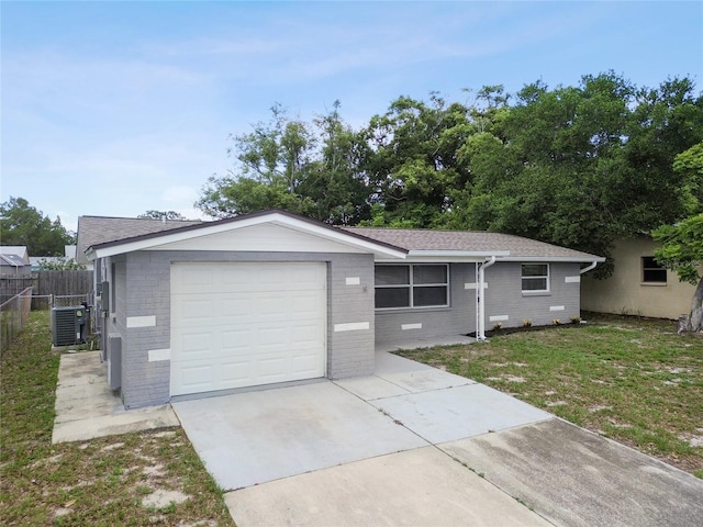 ranch-style home with central AC, a front lawn, and a garage