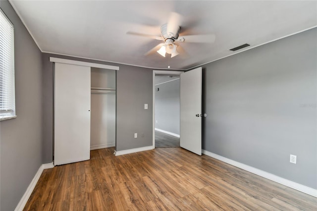 unfurnished bedroom with wood-type flooring, a closet, and ceiling fan