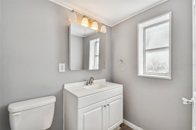 bathroom with vanity, toilet, and ornamental molding