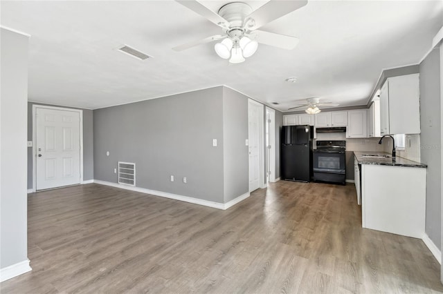 kitchen featuring ceiling fan, sink, white cabinets, black appliances, and light wood-type flooring