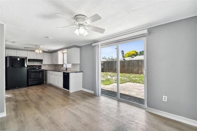 kitchen with ceiling fan, sink, light hardwood / wood-style floors, white cabinets, and black appliances