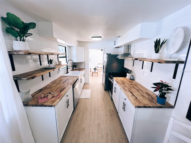 kitchen with white cabinetry, appliances with stainless steel finishes, wooden counters, and light hardwood / wood-style floors