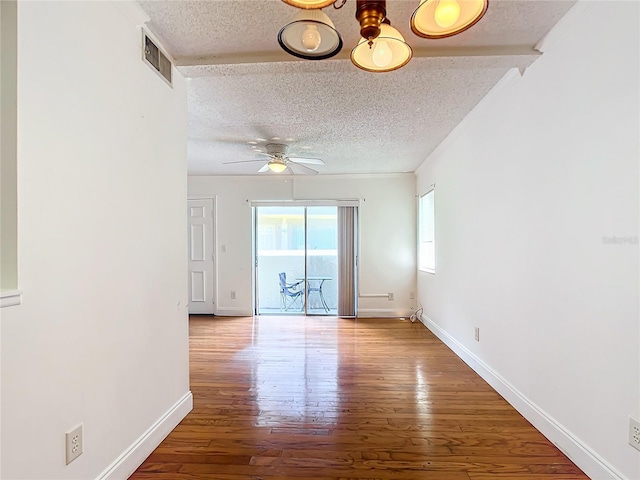 spare room with hardwood / wood-style flooring, ceiling fan, and a textured ceiling