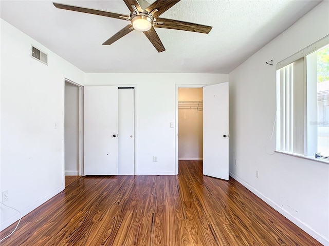 unfurnished bedroom featuring ceiling fan and dark hardwood / wood-style flooring