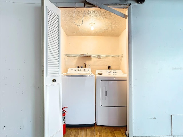 washroom with washer and dryer and light hardwood / wood-style floors