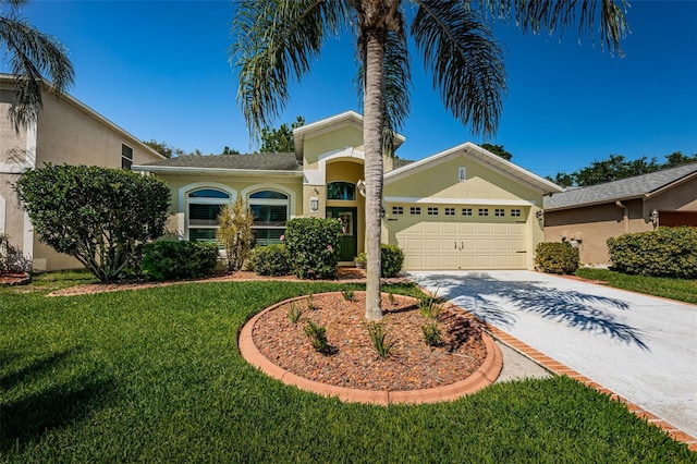 mediterranean / spanish home featuring a front lawn and a garage