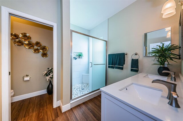 bathroom with wood-type flooring, vanity, toilet, and an enclosed shower