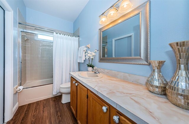 full bathroom with hardwood / wood-style floors, vanity, toilet, and shower / bathtub combination