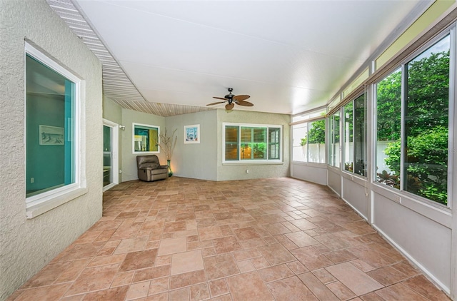 unfurnished sunroom featuring ceiling fan