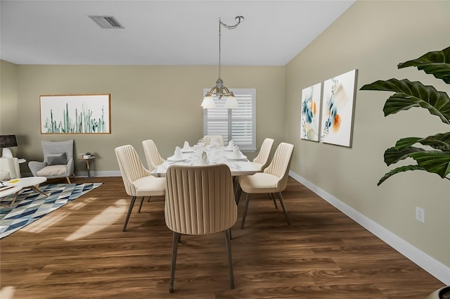 dining space with a chandelier and dark wood-type flooring