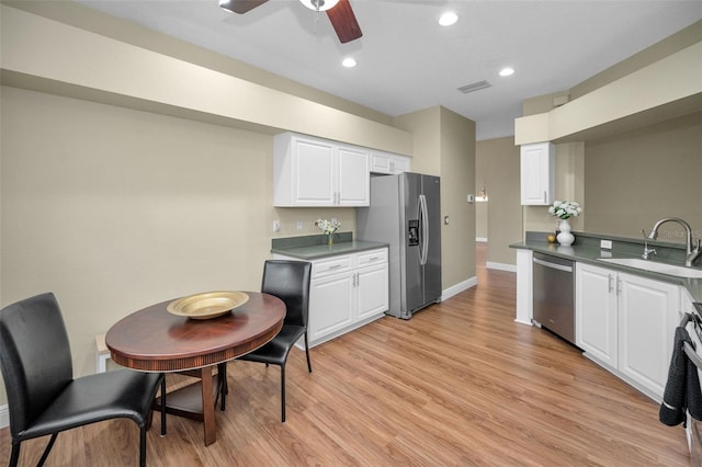 kitchen with white cabinetry, sink, ceiling fan, stainless steel appliances, and light wood-type flooring