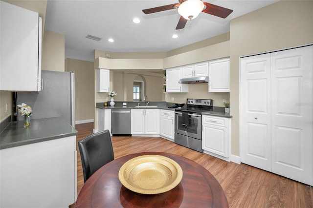 kitchen with appliances with stainless steel finishes, light wood-type flooring, ceiling fan, sink, and white cabinets