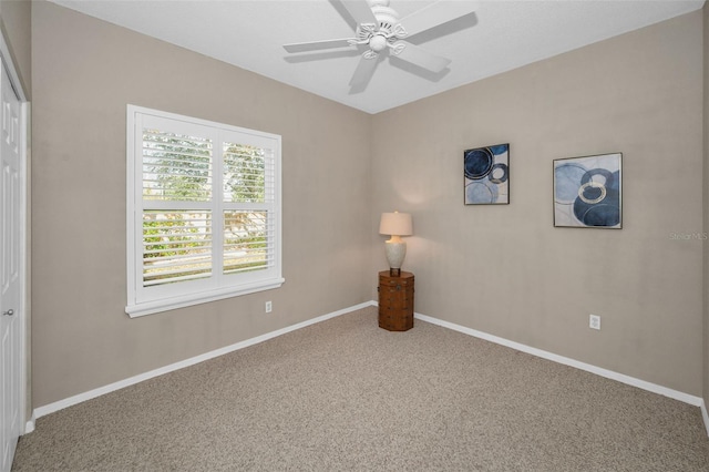 carpeted spare room featuring ceiling fan