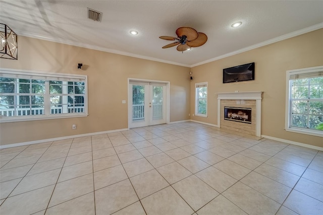 unfurnished living room with a wealth of natural light, ceiling fan, light tile patterned floors, and ornamental molding