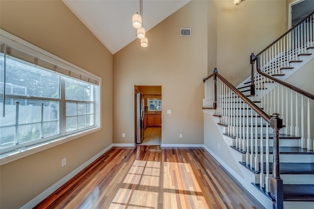 foyer featuring hardwood / wood-style flooring, plenty of natural light, and high vaulted ceiling