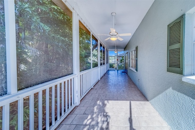 unfurnished sunroom with ceiling fan