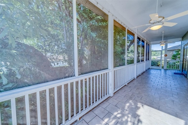 unfurnished sunroom featuring ceiling fan