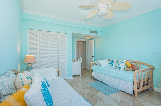 tiled bedroom with crown molding, ceiling fan, and a closet