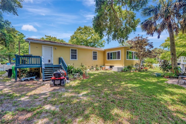 rear view of property with a lawn and a wooden deck